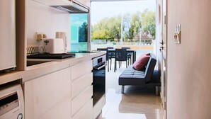 A modern kitchen with a dining area and a sofa. - Phaedrus Living: Seaside Luxury Flat Harbour 102 (Paphos)