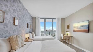 A hotel room with two beds, a balcony, a desk, and a view of the city. - Spectacular Apartment w/Balcony+ Pool+ Near Beach (Hallandale Beach)