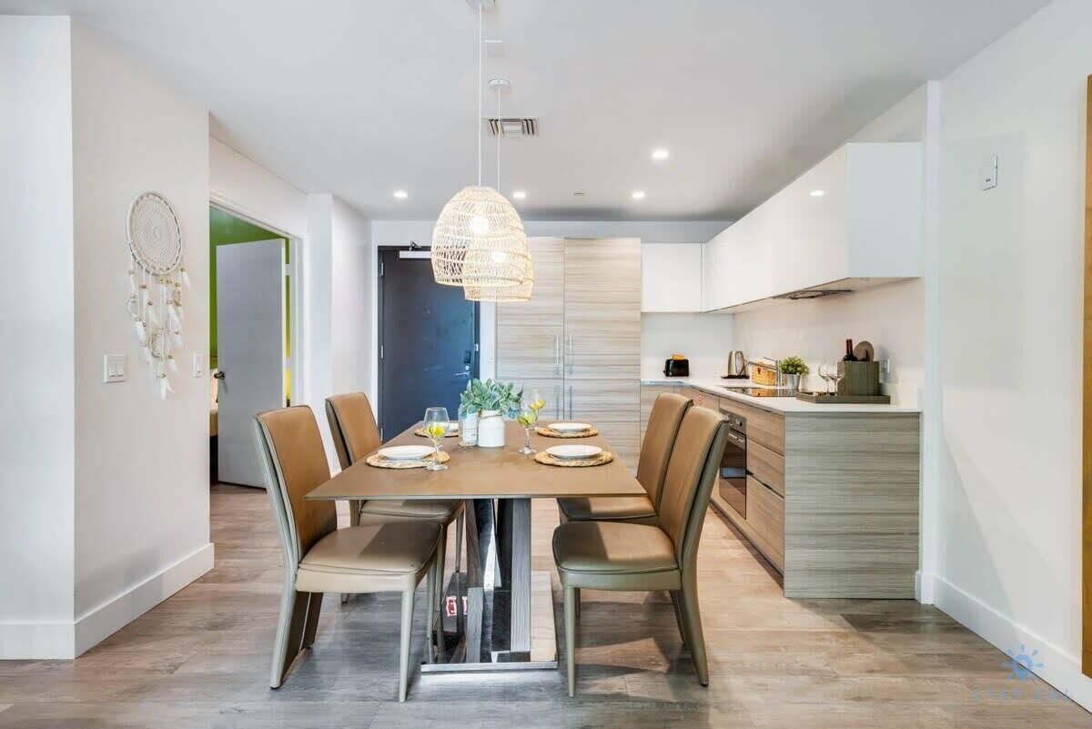 Een moderne eethoek met een centrale tafel, stoelen en een hanglamp.