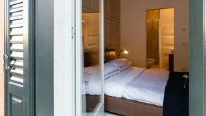 A bedroom with a bed, a mirror, and a door.