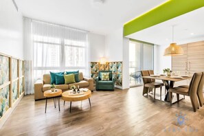 Relax in this stylish living space with a large sofa, dining area, and plenty of natural light.