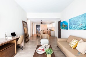 Uma sala de estar moderna com uma escrivaninha, sofá e obras de arte nas paredes.