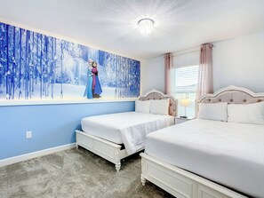 A bedroom with two beds, a chandelier, and a large wall mural.