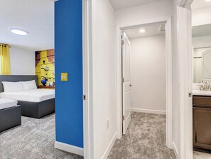 Une chambre d’hôtel avec un lit, un bureau et une salle de bain équipée d’un miroir.