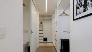 A modern, narrow hallway leading to a walk-in closet with white shelving and a radiator. - w* | Modern 1BR in New Building in Roma Norte (Ciudad de México)