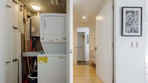 A laundry area with a washing machine, a drying rack, and cleaning tools. - w* | Modern 1BR in New Building in Roma Norte (Ciudad de México)