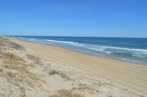 A beach with a sandy shore and ocean waves.