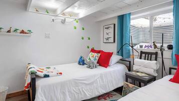 Cozy retreat with two beds, a desk, and dinosaur-themed decor.