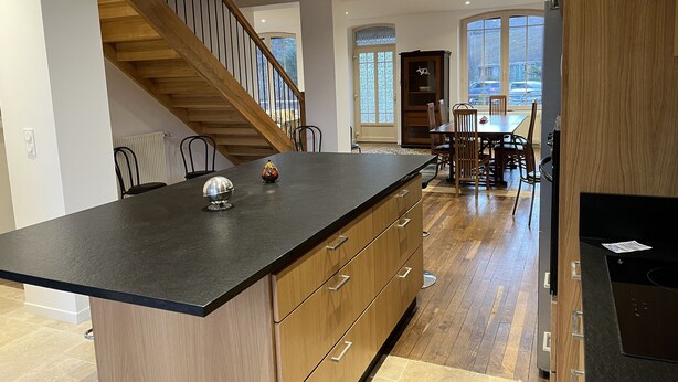 Una cocina moderna con una escalera de madera, un comedor con un amplio ventanal y vistas a la ciudad.