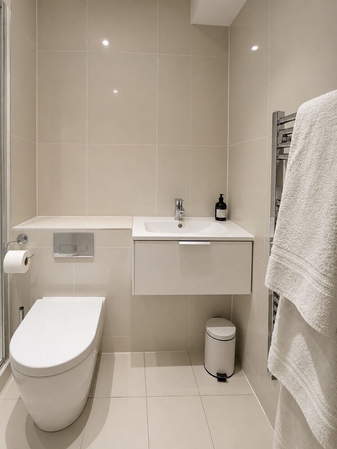 Un baño moderno con inodoro, lavabo y zona de ducha.
