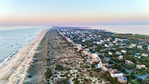Stunning coastal homes line the beachfront, offering easy access to the sandy shore.