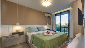 A bedroom with a bed, bedside tables, a nightstand, a window with a view, and an air conditioning unit. - Waiwai Cumbuco pé na areia por Carpediem (Caucaia)