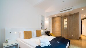 A modern hotel room with a large bed, a bedside table, a built-in wardrobe, and a small seating area. - Vienna Residence, City Hall - Parliament #6408 (Vienna)