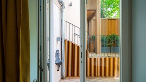 An open sliding door leading to a wooden deck with a metal railing and a small outdoor sink. - Vienna Residence, City Hall - Parliament #6408 (Vienna)