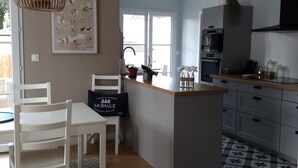 Een moderne keuken met een centraal eiland, witte kastjes en een vloer met patroon.