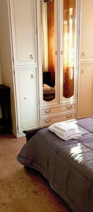 Comfortable bedroom with a large wardrobe and a plush bed.