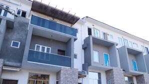 A multi-story residential building with balconies, large windows, and a brick facade. - Luxury House - Sleeps 8 & Free Parking (Abuja)