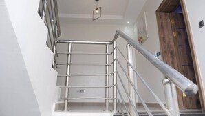 A modern staircase with metal railings and a wooden door at the top. - Luxury House - Sleeps 8 & Free Parking (Abuja)