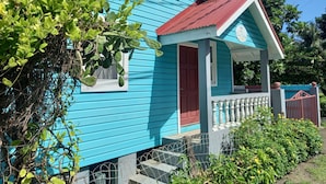 Ein blaues Haus mit roter Tür und einer Veranda.