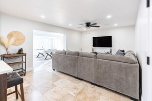 Relax in a spacious living area with a sofa, flat-screen TV, and dining space.