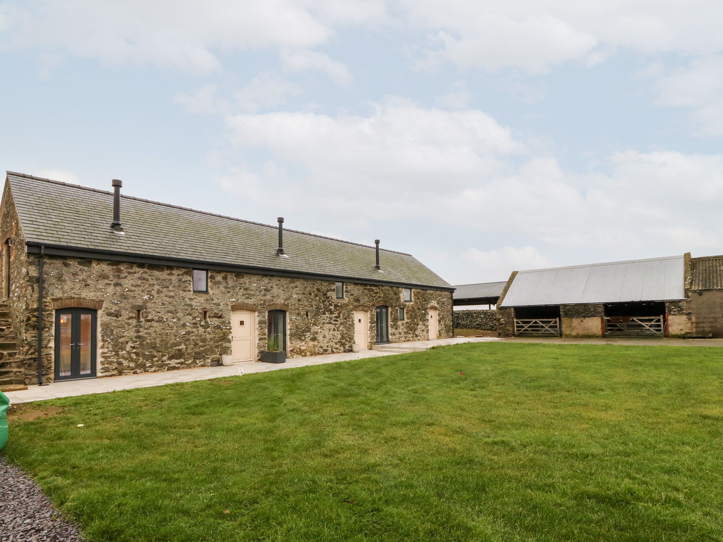 A stone building with a flat roof and a grassy courtyard.