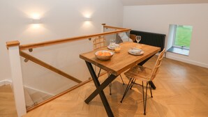 Un comedor con una mesa de madera, sillas y vistas al exterior a través de una ventana.