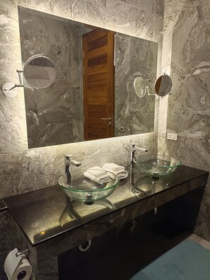 A bathroom with two glass bowl sinks, a wooden door, and a large mirror. - A luxury, modern and stylish sea view villa - 400 meters to the beach (Koh Phangan)