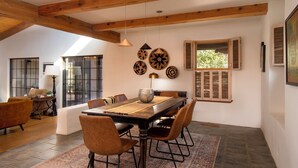 A dining area with a wooden table, chairs, and a patterned rug. - Sunlit 3 bedroom, enclosed dog friendly yard in quiet neighborhood (Santa Fe)