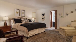 A bedroom with a bed, bedside tables, a chair, a sofa, and a door leading to another room. - Sunlit 3 bedroom, enclosed dog friendly yard in quiet neighborhood (Santa Fe)