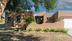 A modern house with a stucco exterior, a blue door, and a garage. - Sunlit 3 bedroom, enclosed dog friendly yard in quiet neighborhood (Santa Fe)