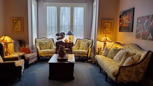 A traditional living room with two armchairs, a sofa, a coffee table, and a fireplace. - The Lark & Loon Inn (Annapolis Royal)