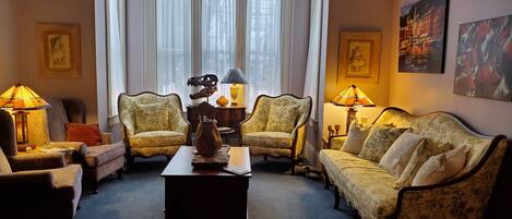 A traditional living room with two armchairs, a sofa, a coffee table, and a fireplace.