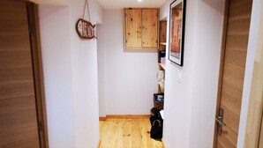 A hallway with wooden flooring, white walls, and wooden doors. There is a wooden cabinet with a picture frame on the wall. - Comfortable apartment 300 m from the beach (Dinard)