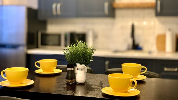 A kitchen with dark cabinets, a wooden countertop, and a small potted plant. - Cozy Downtown Suite - Walking Distance to Restaurants & shops - Quiet Area (Golden)