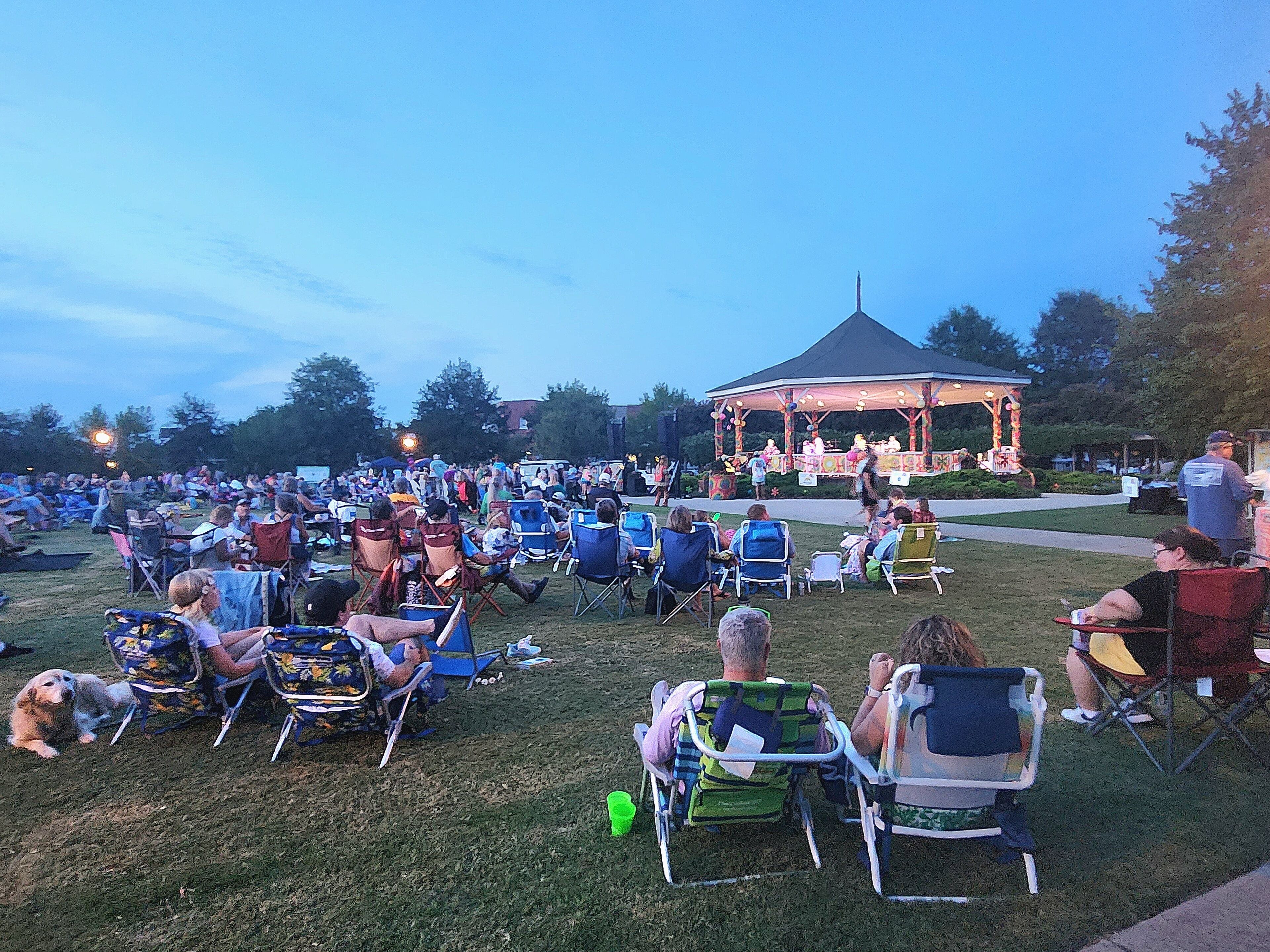 An outdoor seating area with lawn chairs and a gazebo in the background.