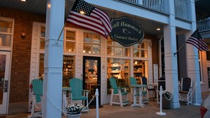 A storefront with a sign reading "Gull Hammock Gourmet Market," featuring a brick facade, white railings, and outdoor seating with chairs. - Beach, beach, in historic Cape Charles. Lovely 2BR Apt. 1 Block from beach (Cape Charles)