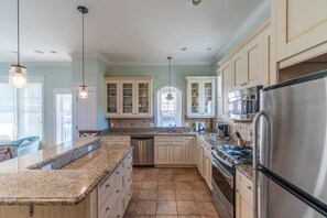 Enjoy cooking in this well-equipped kitchen with a central island, stainless steel appliances, and ample storage.