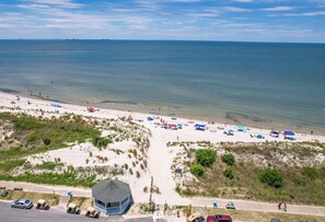 A beach with a dune buggy rental area, a lifeguard tower, and a clear view of the ocean.