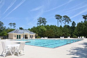 Relax by the pool surrounded by lush greenery and comfortable lounge seating.