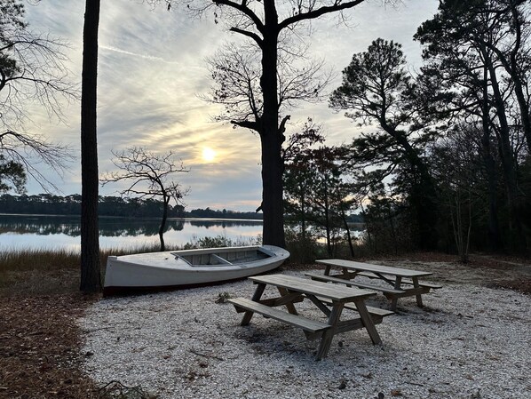 Relax by the serene lake, surrounded by mature trees and a maintained outdoor space perfect for picnics and recreation.