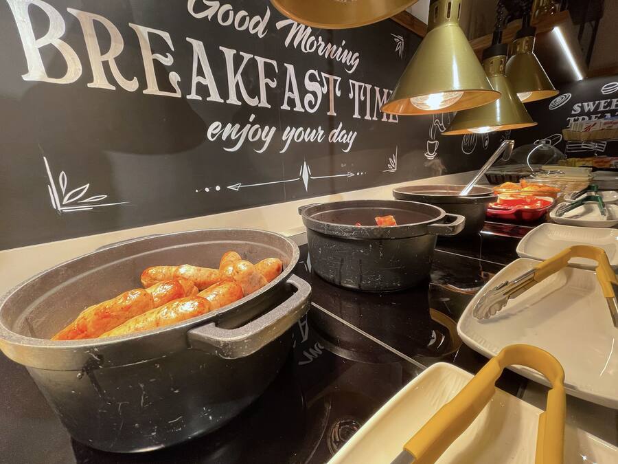 Un buffet de petit-déjeuner proposant divers plats et ustensiles.