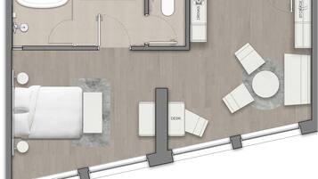 A hotel room layout with a bed, desk, two chairs, a small table, a sofa, a round table, a coffee table, a TV, a wardrobe, a bathroom with a sink, toilet, and a bathtub.
