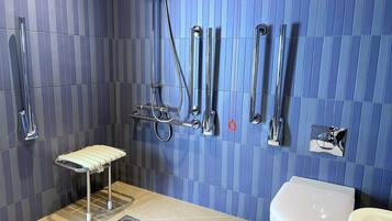 A bathroom with a shower, toilet, and a small bench.