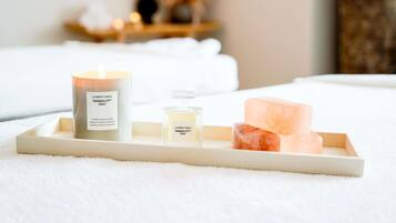 Un plateau avec une bougie, une bouteille et un savon.