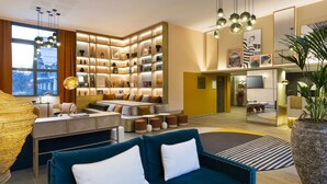 A modern living room with a sofa, a coffee table, and a bookshelf filled with books and decorative items.