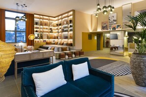 Un salon moderne comprenant un canapé, une table basse et une bibliothèque remplie de livres et d’objets décoratifs.