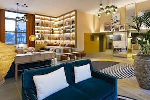 A modern living room with a sofa, a coffee table, and a bookshelf filled with books and decorative items.