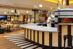 A modern kitchen with a central island, a built-in oven, and a bar area with shelves of bottles.