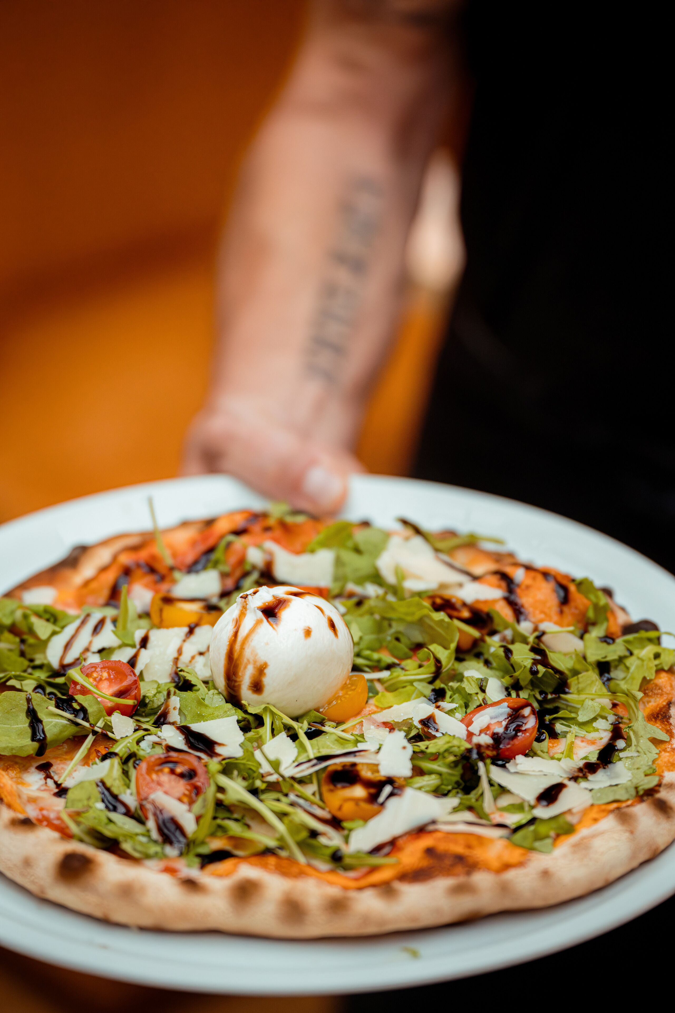 A pizza with various toppings on a white plate.