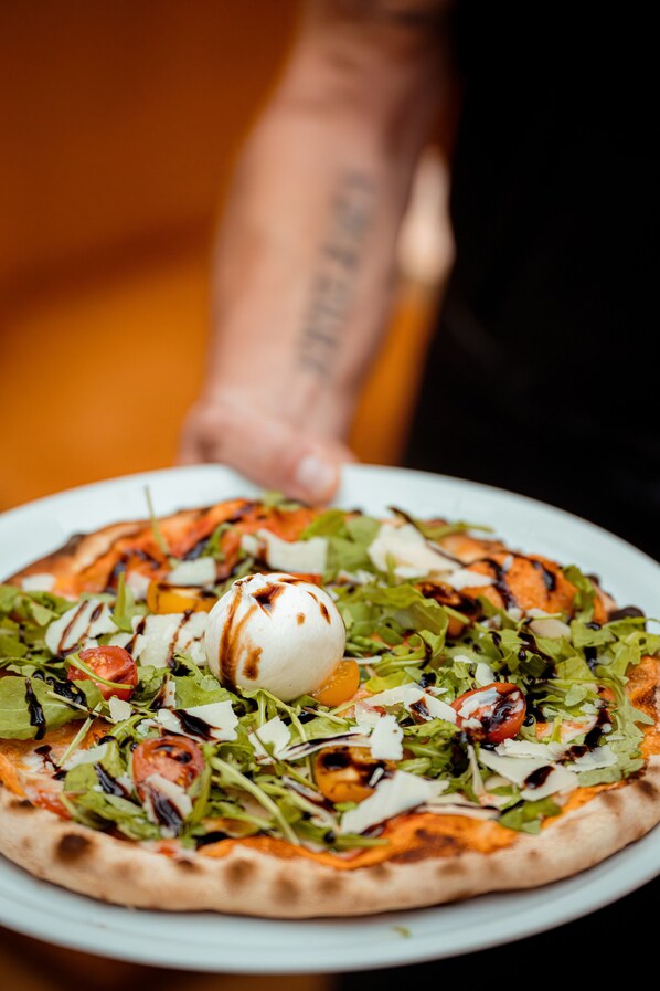 A pizza with various toppings on a white plate.